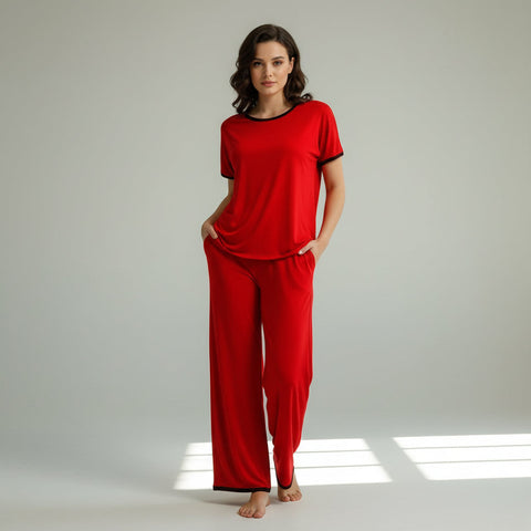 A plain red round neck half sleeves top with flappers trousers, displayed on a hanger. A person is touching the red top to show the texture and fit.