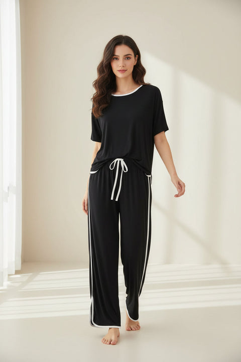 A black and white striped shirt with round neck and half sleeves, paired with matching palazzo trousers with a drawstring waist.
